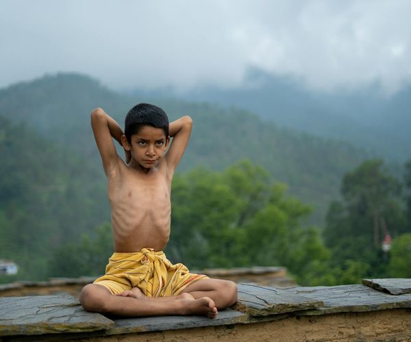 Woman practicing yoga outdoors during a vibrant sunrise.